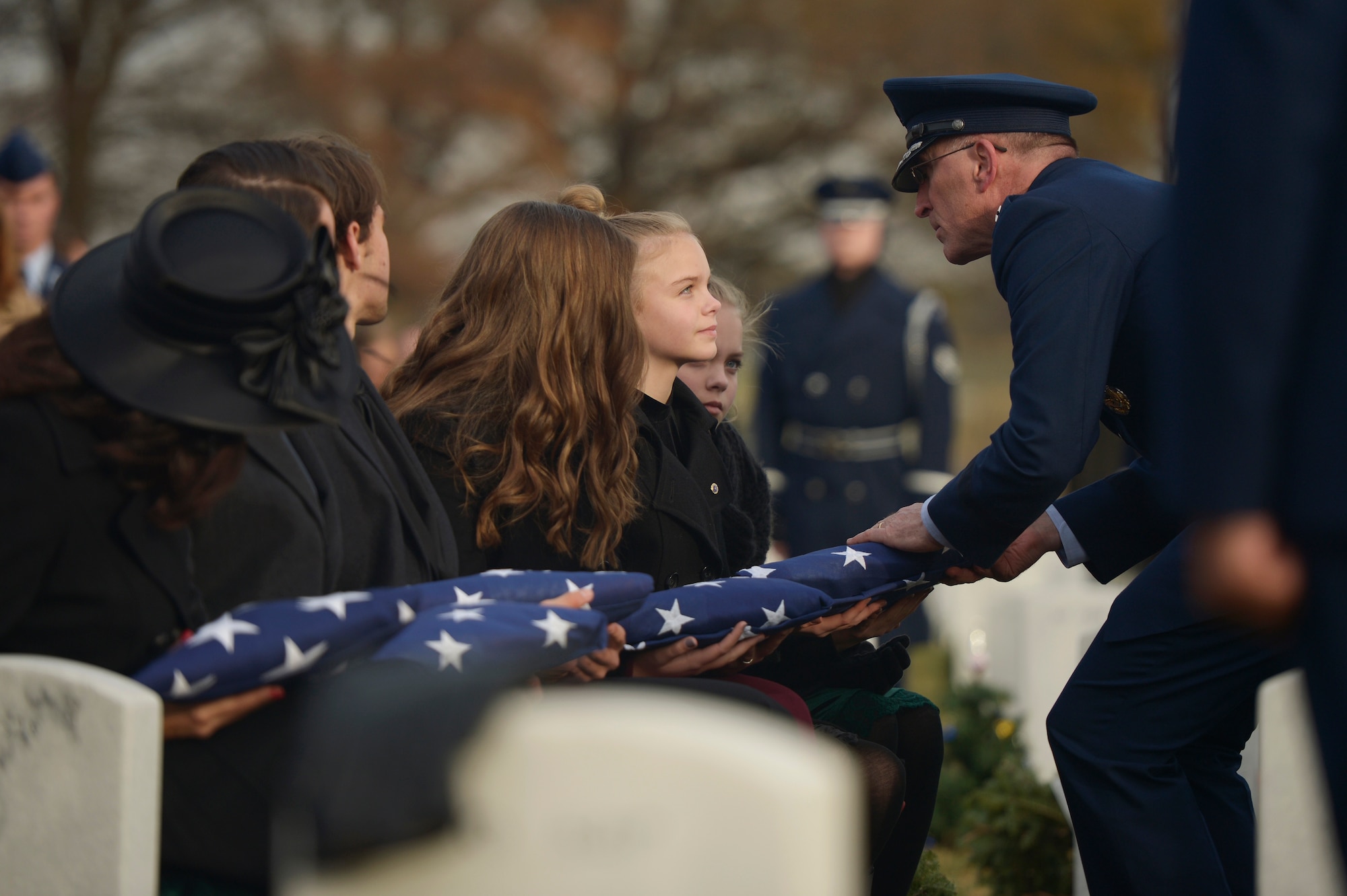 Maj. Gen. Scott Vander Hamm, the Air Force assistant deputy chief of staff of operations, presents a flag to Annalise during the interment for her father, Maj. Troy Gilbert, at Arlington National Cemetery, Va., Dec. 19, 2016.  He is survived by his mother and father, Kaye and retired Senior Master Sgt. Ron Gilbert; sister, Rhonda Jimmerson; wife, Ginger Gilbert Ravella; sons, Boston and Greyson; and daughters, Isabella, Aspen and Annalise. (U.S. Air Force photo/ Tech. Sgt. Joshua DeMotts)