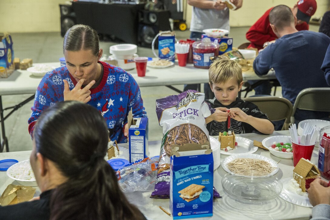 U.S. Marines and their family members build gingerbread houses during the I Marine Expeditionary Force Headquarters Group Holiday Party at Marine Corps Base Camp Pendleton, Calif., Dec. 14, 2016. The Marines and their family members celebrated the holiday season by building gingerbread houses, decorating stockings and designing Christmas ornaments while enjoying a holiday meal in camaraderie. (U.S. Marine Corps photo by Cpl. Alvin Pujols)