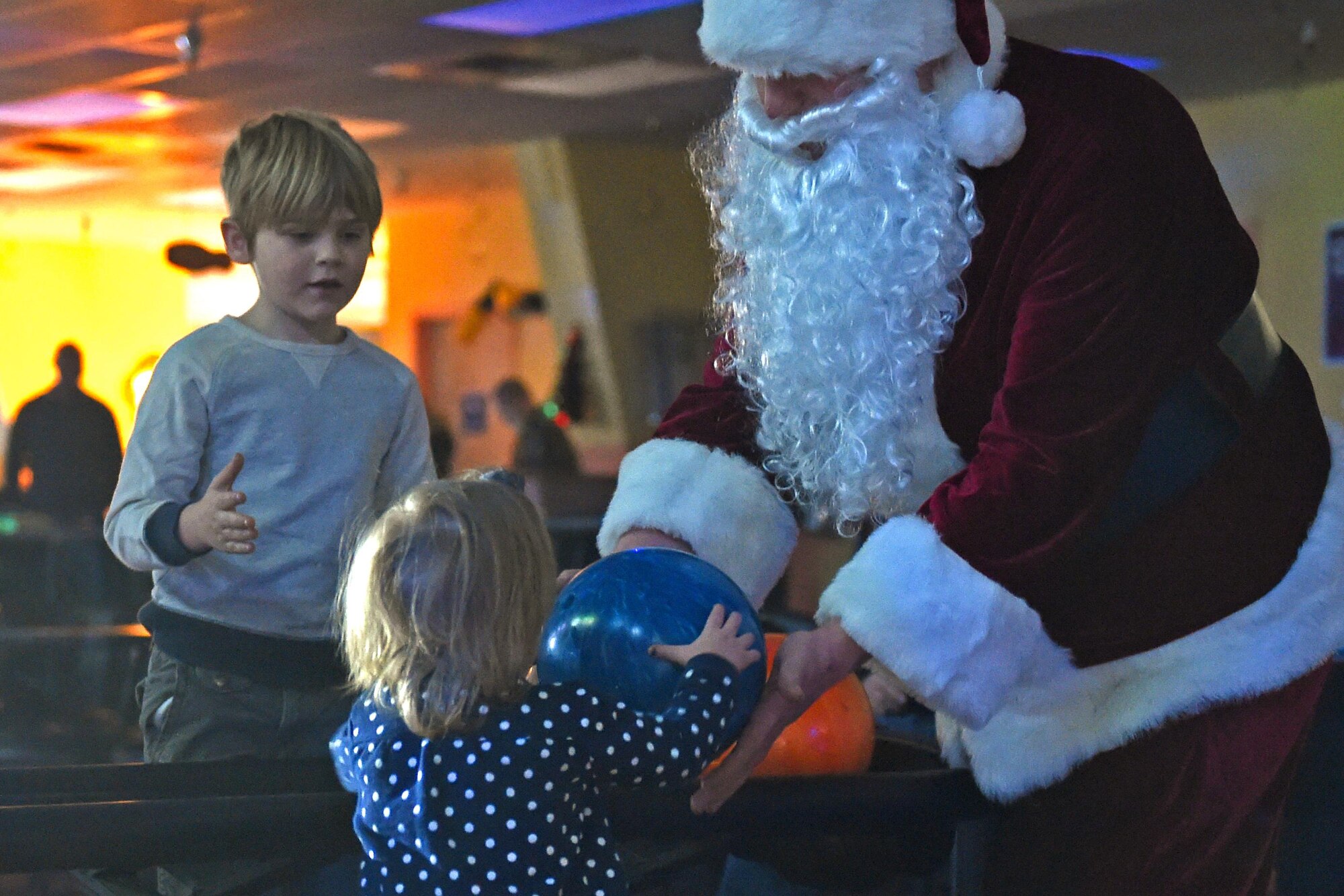 Santa Claus helps an aspiring bowler at the Polar Bowl at Joint Base Elmendorf-Richardson, Alaska, Dec. 17, 2016. The Polar Bowl hosted a Bowling with Santa event for children of all ages to bowl alongside Santa Claus and receive presents. 
