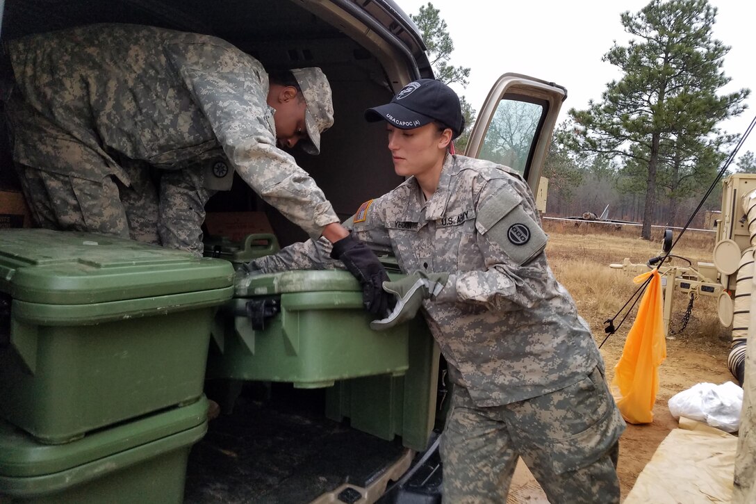 Army Spc. Savannah Yerdon, right, a culinary specialist assigned to 1018th Quartermaster Company, and Army Sgt. Leroy McKinley, a heavy vehicle operator and culinary specialist assigned to 942nd Transportation Company, unload meal containers in preparation for breakfast at Fort Bragg, N.C., Dec. 12, 2016. Yerdon and McKinley were part of a six-person food service crew that provided meal rations for hundreds of soldiers during Operation Toy Drop XIX.  Army photo by Capt. Ebony Malloy
