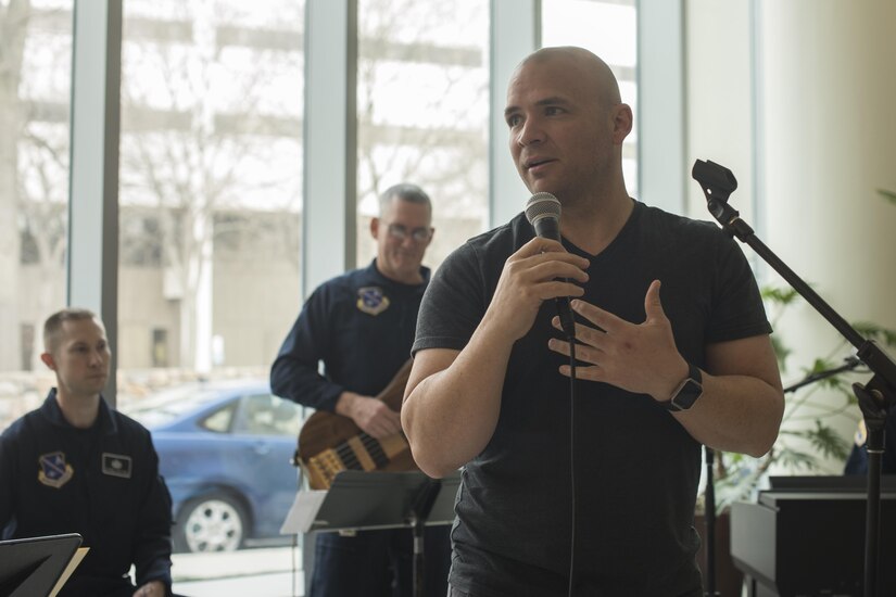 U.S. Army Sgt. Andrew Bell, National Intrepid Center of Excellence patient, speaks to the audience before a performance at Walter Reed National Military Medical Center in Bethesda, Md., Dec. 13, 2016.  U.S. Air Force Band Max Impact accompanied Bell as he performed “The Christmas Song” at the NICoE Creative Arts Café. NCAC is performance platform for NICoE patients and staff to share creativity though creative arts once a month. (U.S. Air Force photo by Airman 1st Class Rustie Kramer)