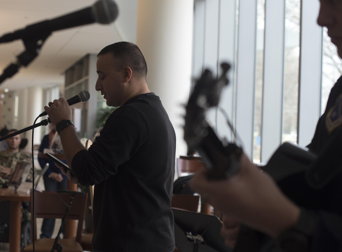 Marine Staff Sgt. Anthony Mannino, National Intrepid Center of Excellence patient, performs a spoken word piece at NICoE Creative Arts Café at Walter Reed National Military Medical Center in Bethesda, Md., Dec. 13, 2016. U.S. Air Force Band’s Max Impact accompanied Mannino spoken word piece with music from King’s of Leon’s song “Walls.” NCAC is performance platform for NICoE patients and staff to share creativity though creative arts once a month. (U.S. Air Force photo by Airman 1st Class Rustie Kramer)