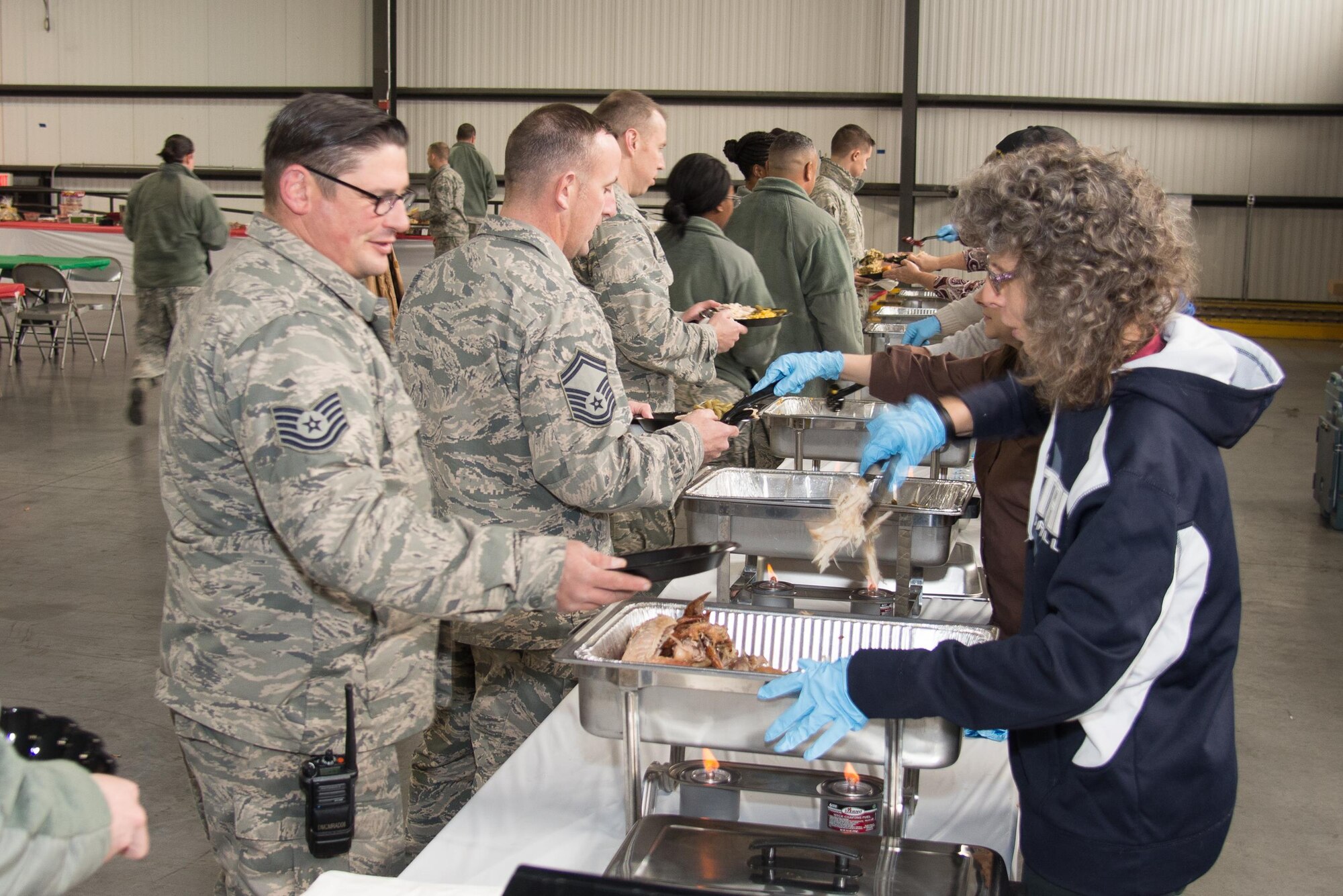 Team Dover Airmen go through the serving line at the annual Feed the Troops lunch Dec. 16, 2016, on Dover Air Force Base, Del. 2016 marks the 13th year the lunch has been held at Dover AFB.  The food was donated by veteran’s organizations, prepared at Dover Downs and served by volunteers from the local community.  (U.S. Air Force photo by Mauricio Campino)