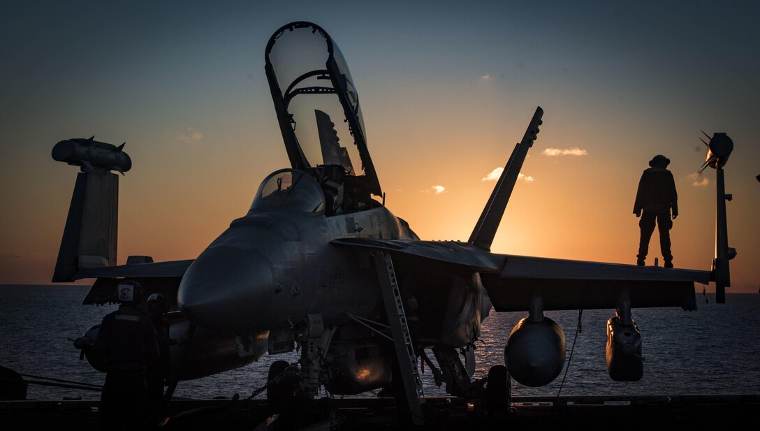 Navy Petty Officer 3rd Class Alexis Rey conducts preflight checks on an EA-18G Growler on the flight deck of the aircraft carrier USS Dwight D. Eisenhower in the Mediterranean Sea, Dec. 11, 2016. The aircraft is assigned to Electronic Attack Squadron 130. Navy photo by Petty Officer 2nd Class Ryan Kledzik