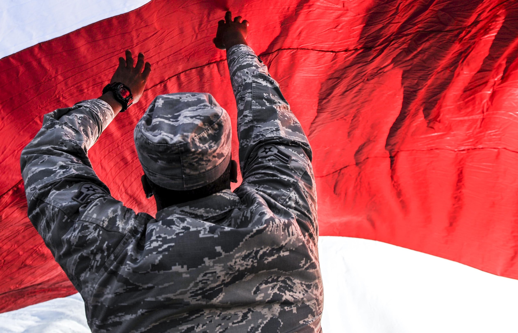 Airman 1st Class Corey Mitchell, 99th Air Base Wing Public Affairs broadcast engineer, holds up the American flag at Sam Boyd Stadium before the Las Vegas Bowl, Dec. 17, 2016. The Las Vegas Bowl featured the Houston Cougars facing off against the San Diego State Aztecs. (U.S. Air Force photo by Airman 1st Class Kevin Tanenbaum/Released)