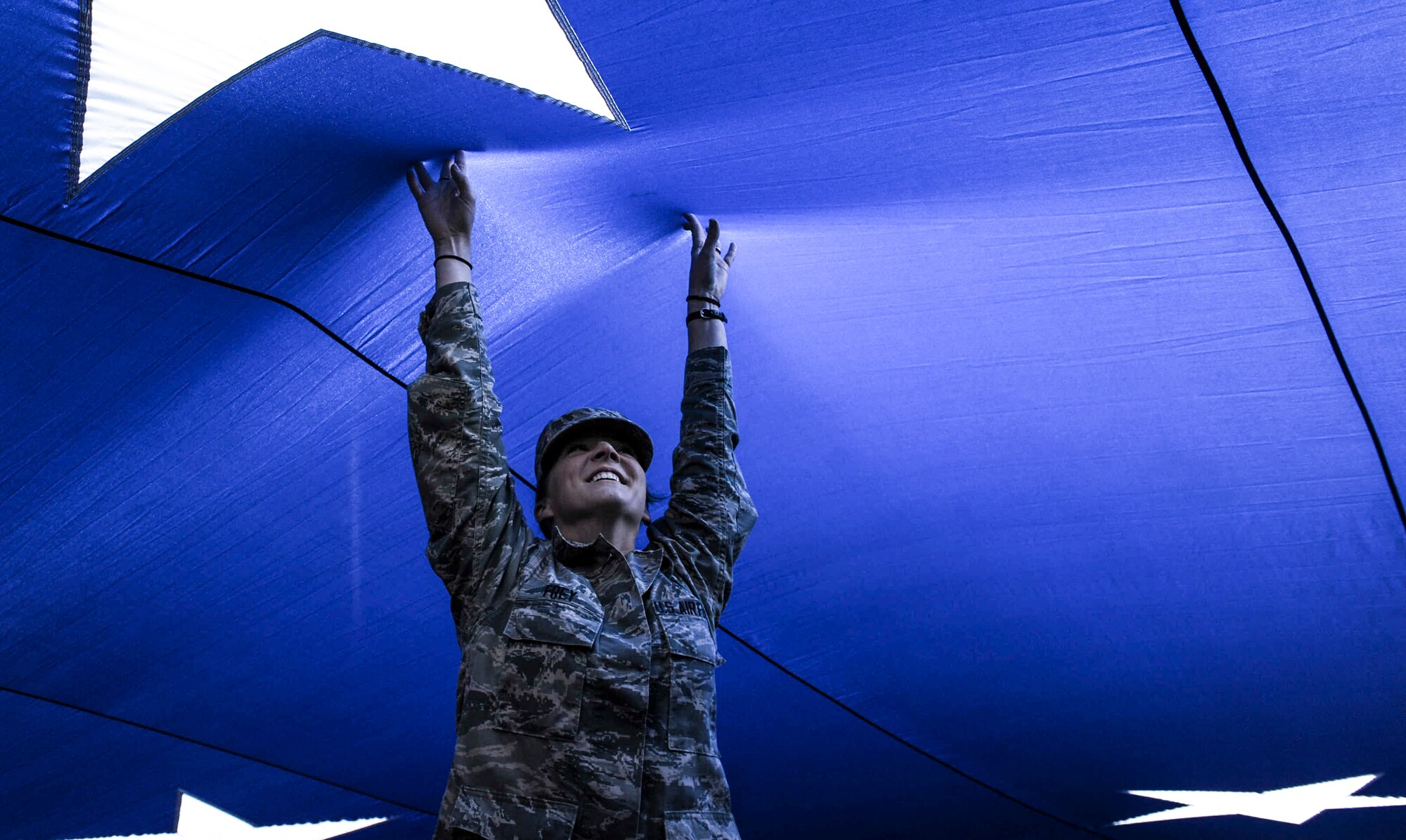 An Airman holds up the American flag at Sam Boyd Stadium before the Las Vegas Bowl, Dec. 17, 2016. The oversized American flag weighed nearly one thousand pounds and needed over 150 Airmen to hold. (U.S. Air Force photo by Airman 1st Class Kevin Tanenbaum/Released)