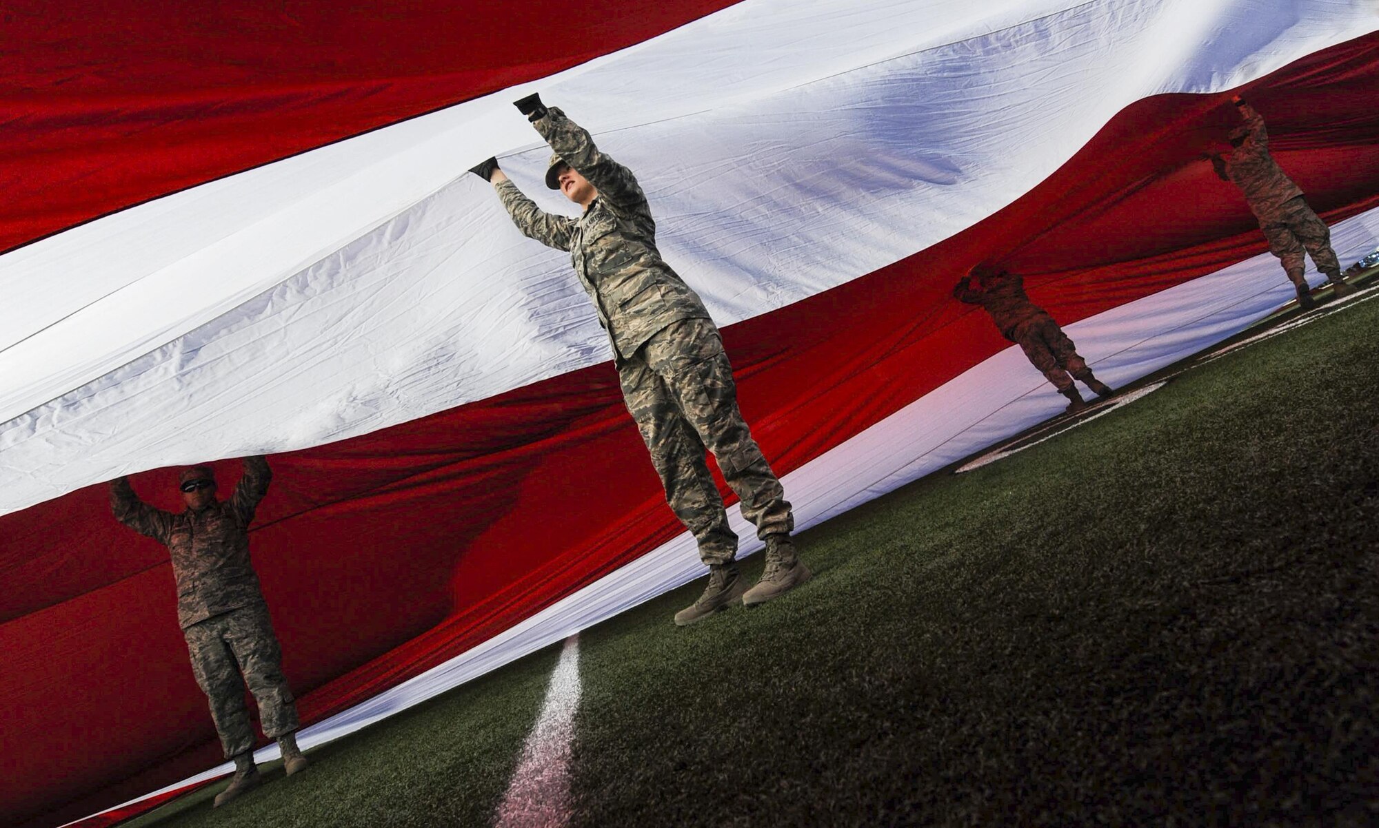 Airmen from Nellis and Creech Air Force Bases hold up the American flag at Sam Boyd Stadium before the Las Vegas Bowl, Dec. 17, 2016. The Airmen who held the flag were afforded the opportunity to stay and watch the game between the Houston Cougars and San Diego State Aztecs. (U.S. Air Force photo by Airman 1st Class Kevin Tanenbaum/Released)