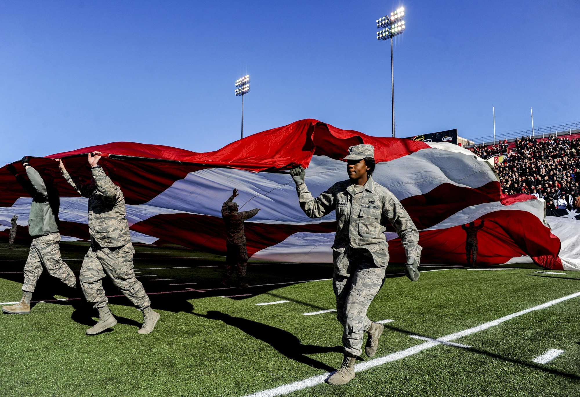 Airmen from Nellis and Creech Air Force Bases unveil the American Flag at Sam Boyd Stadium during the Las Vegas Bowl, Dec. 17, 2016. San Diego State senior Donnel Pumphrey earned the Rossi T. Ralenkotter Most Valuable Player Trophy by rushing for 115 yards on 19 carries during the game. (U.S. Air Force photo by Airman 1st Class Kevin Tanenbaum/Released)