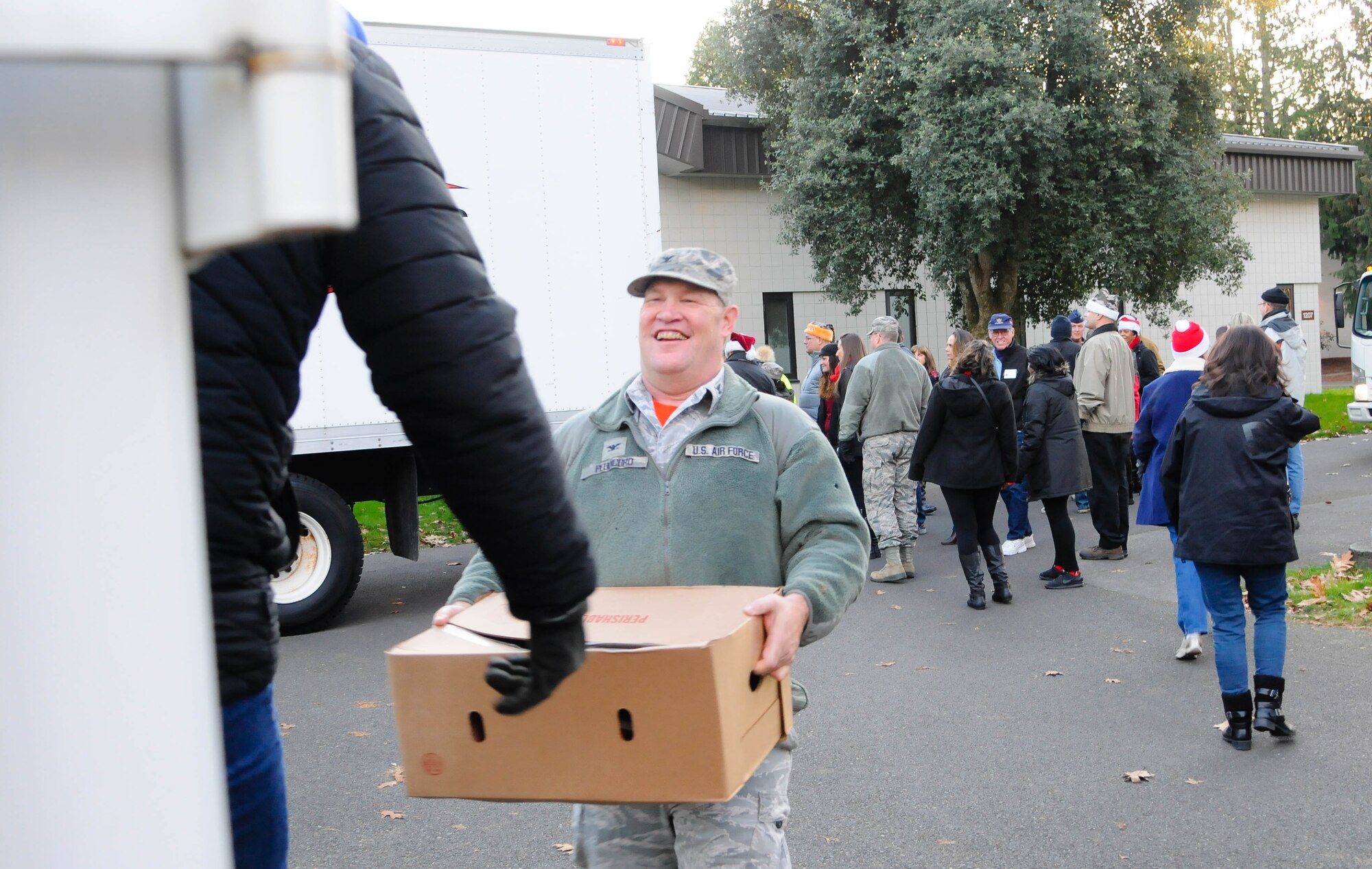 Col. Kirk Peddicord, 446th Airlift Wing Maintenance Group commander carries a box of hams during Operation Ham Grenade. The seventh annual event provides holiday meals to members of the 446th AW. (U.S. Air Force Reserve photo by David Yost)