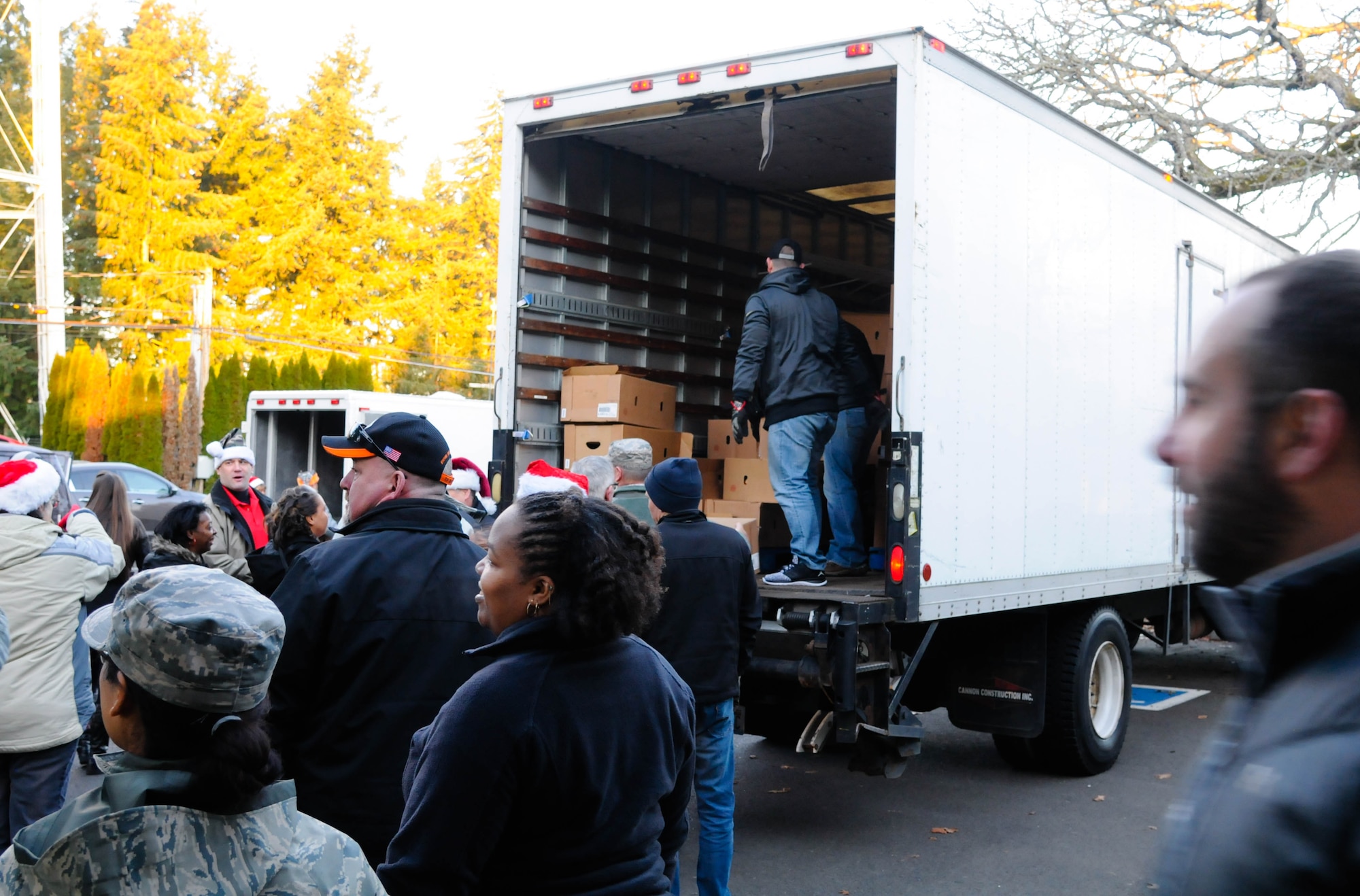 Military and civilian volunteers help unload boxes of hams in support of Operation Ham Grenade Dec. 12. More than 150 hams were delivered to the 446th Airlift Wing. (U.S. Air Force Reserve photo by David Yost)