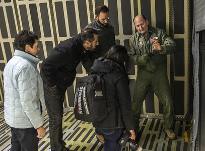Col. Thomas K. Smith Jr., 433rd Airlift Wing commander, explains how the cargo door was blown out on the ill-fated C-5 flight during Operation Babylift April 4, 1975 in Vietnam. Retired Col. Regina Aune, Aryn Lockhart, Nick Morey, and Charles Khachan from St. George Maronite Catholic Church toured a C-5M Super Galaxy aircraft Dec.19, 2016 at Joint Base San Antonio-Lackland, Texas. Aune and Lockhart were both aboard the flight in 1975.