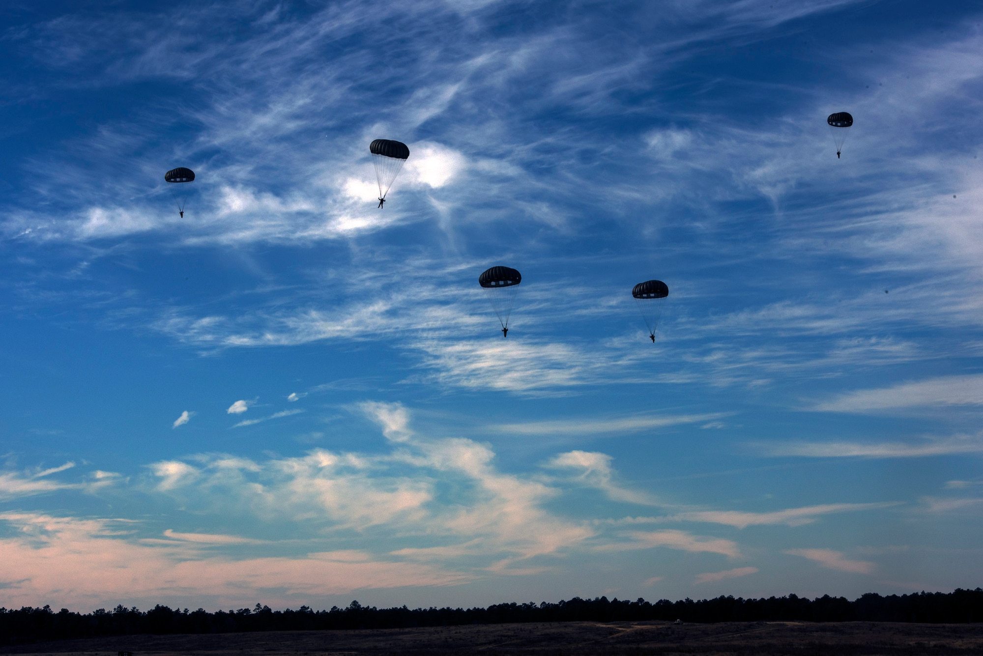 Members of the 820th Base Defense Group and U.S. Army airborne specialists prepare to land after descending from a U.S. Army CASA C-212 during the 19th Annual Randy Oler Memorial Operation Toy Drop, Dec. 15, 2016, at Luzon Drop Zone, Camp Mackall, N.C. Operation Toy Drop is the world’s largest multinational airborne exercise, which started as a mass gift donation for underprivileged kids in the local community. (U.S. Air Force photo by Airman 1st Class Greg Nash)   