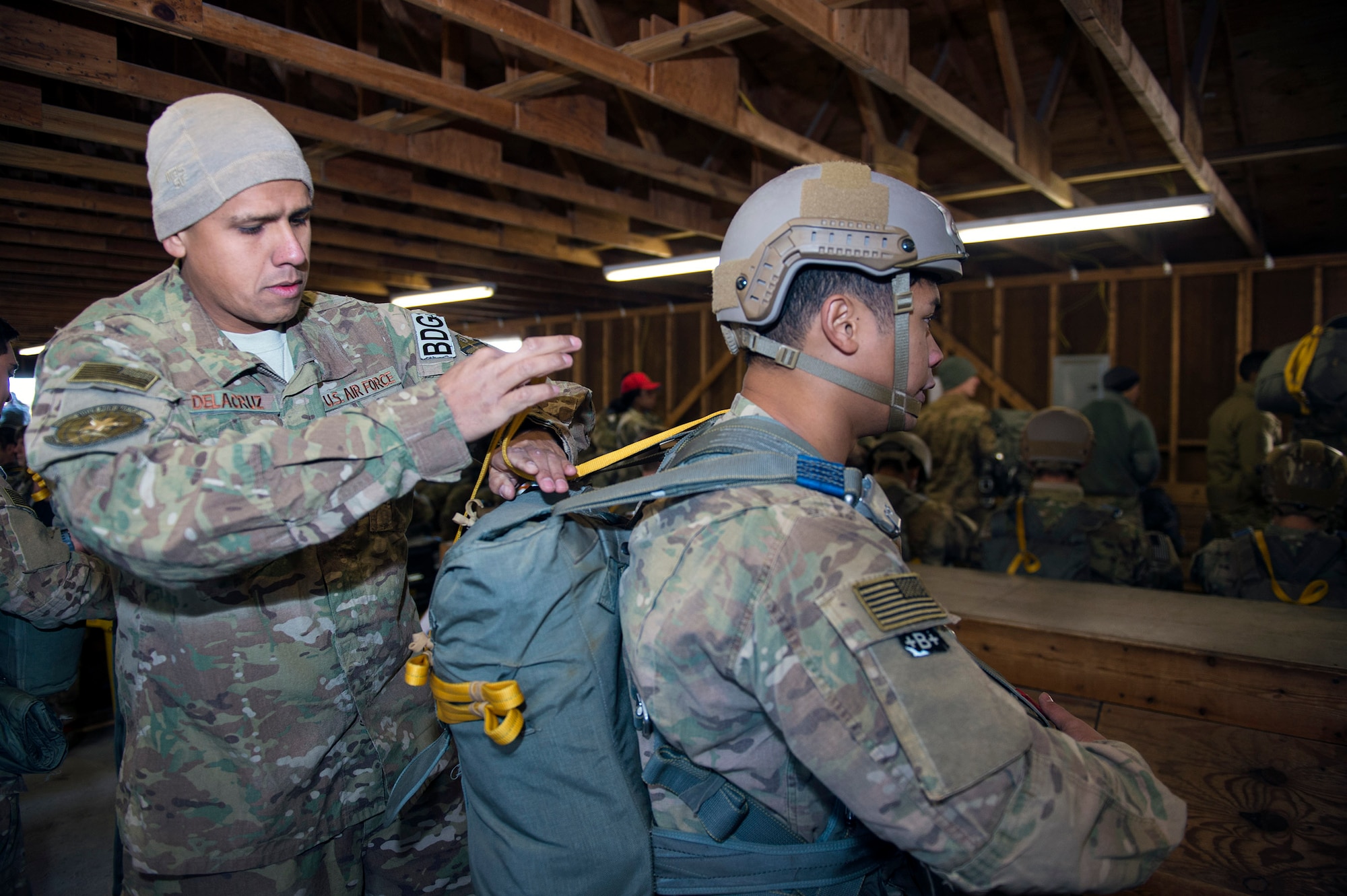 Master Sgt. Jason De La Cruz, 820th Combat Operations Squadron parachute program manager, conducts a jumpmaster personnel inspection on Senior Airman Emmanuel Magbanua, 822d Base Defense Squadron fireteam member, during the 19th Annual Randy Oler Memorial Operation Toy Drop, Dec. 15, 2016, at Mackall Army Air Field, N.C. Airmen from Moody’s 820th Base Defense Group participated in this exercise to enhance their ability to provide force protection with airborne capabilities at a moment’s notice. (U.S. Air Force photo by Airman 1st Class Greg Nash)   