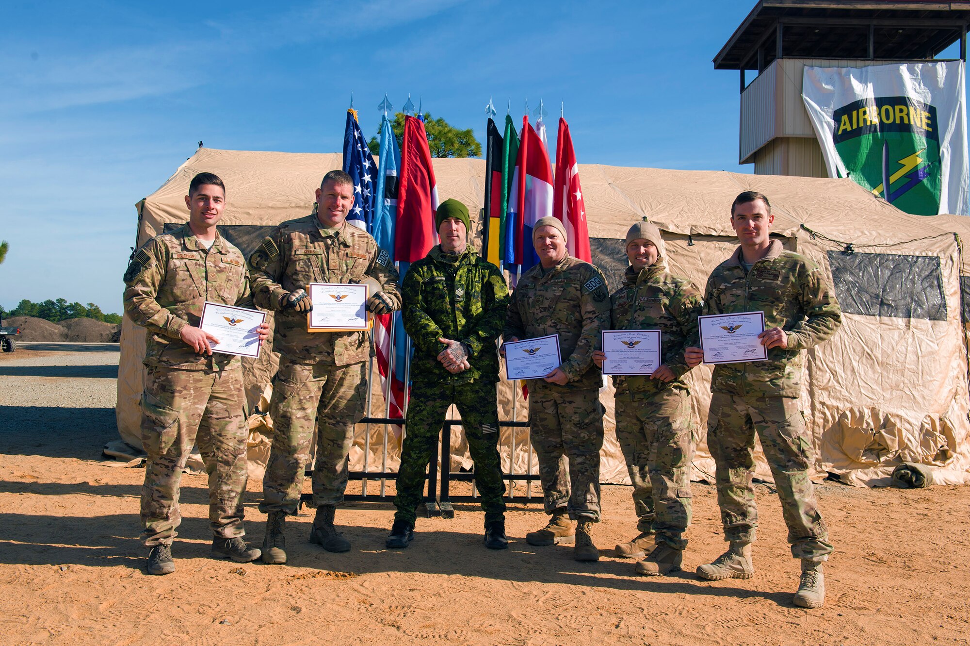 Members of the 93d Air Ground Operations Wing’s 820th Base Defense Group, pose with Sergeant Daniel Jenkins, Canadian army Advanced Warfare Center parachute instructor, after earning their foreign jump certificates during the 19th Annual Randy Oler Memorial Operation Toy Drop, Dec. 15, 2016, at Luzon Drop Zone Camp Mackall, N.C. Members of the 820th BDG were awarded foreign flight wings as an Operation Toy Drop tradition after conducting various jumps and assisting as jumpmasters with international partner nations during their first OTD experience. (U.S. Air Force photo by Airman 1st Class Greg Nash)   