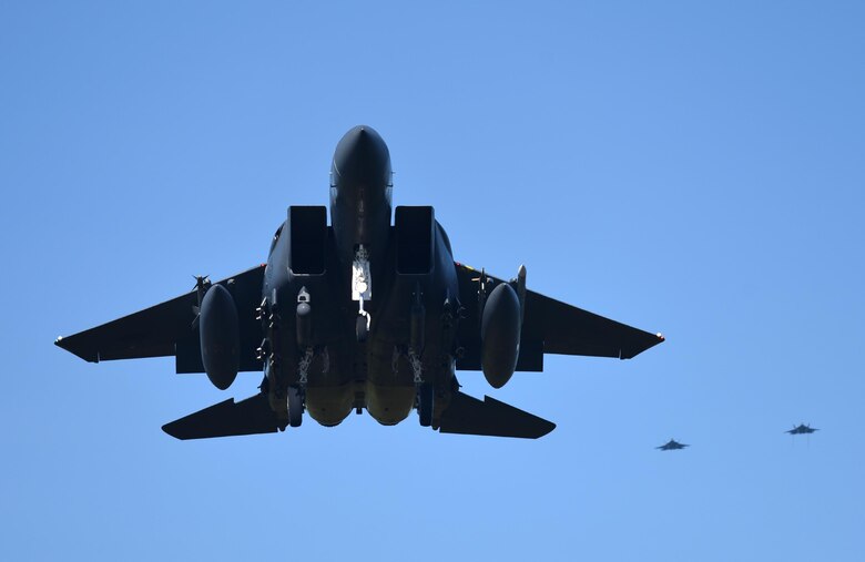 A U.S. Air Force F-15E Strike Eagle from Mountain Home Air Force Base, Idaho, flies with two Tyndall F-22 Raptors following during Checkered Flag 17-1 at Tyndall Air Force Base, Fla., Dec. 16, 2016. During the exercise, fourth- and fifth-generation fighter pilots worked together to complete missions involving multiple airframes including the F-35A Lightning II, F-22 Raptor, F-16CM Fighting Falcon, F-15E, HH-60G Pave Hawk and E-3 Sentry airframes to enhance future Air Force operational capabilities. (U.S. Air Force photo by Staff Sergeant Alex Fox Echols III/Released)