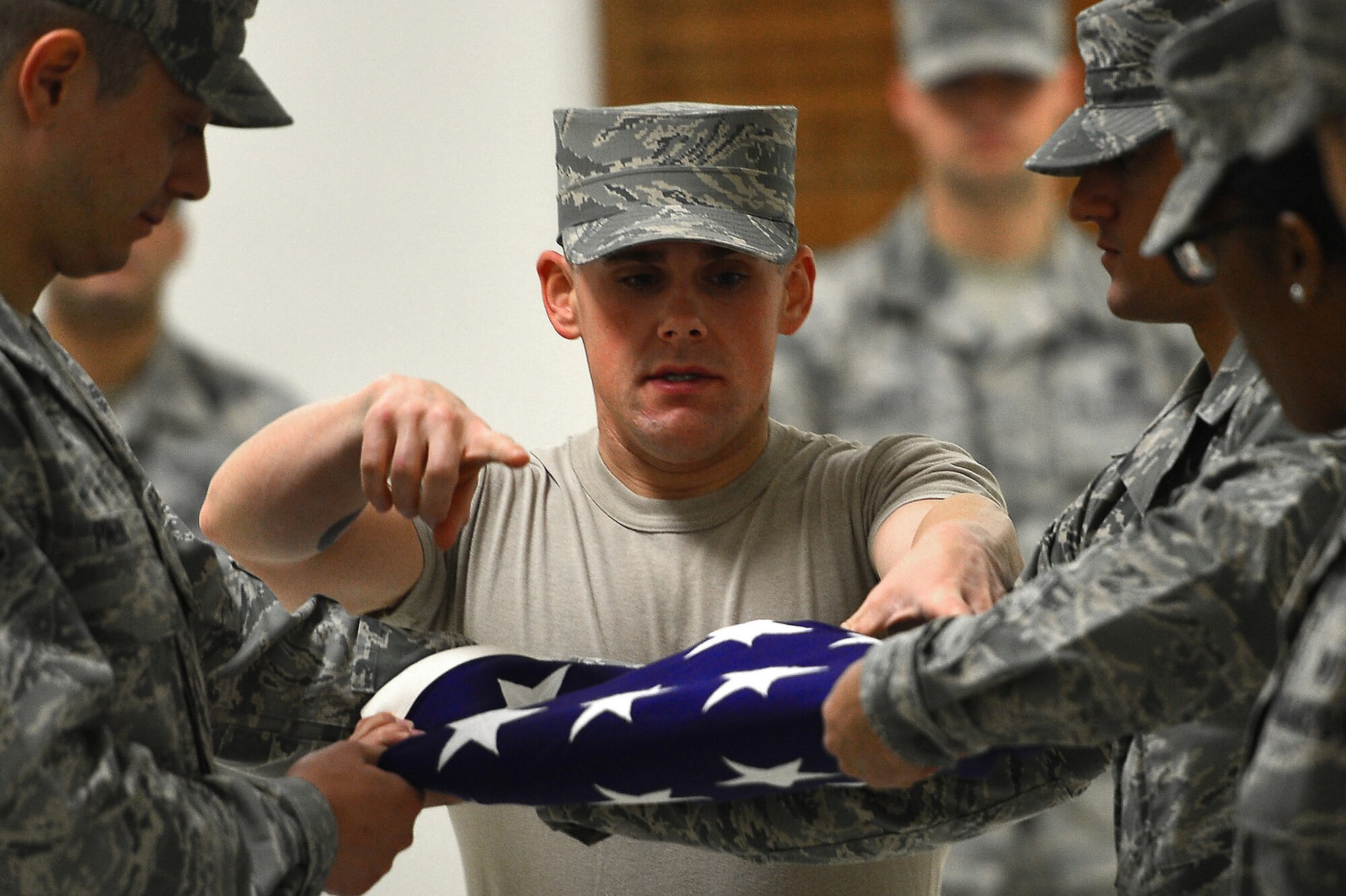 U.S. Air Force Airman 1st Class Dennis Hersey, 20th Force Support Squadron honor guardsman, teaches the proper procedures for folding a flag at Shaw Air Force Base, S.C., Dec. 14, 2016. Hersey helped honor guardsmen hone flag folding skills in preparation for future details. (U.S. Air Force photo by Airman 1st Class Christopher Maldonado)