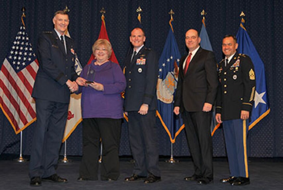Defense Logistics Agency Director Air Force Lt. Gen. Andy Busch presents DLA Energy Supervisory Contract Specialist Cynthia J. Obermeyer with an award for Excellence in Acquisition Management during DLA's 49th Annual Employee Recognition Awards ceremony Dec. 15. 