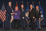 Defense Logistics Agency Director Air Force Lt. Gen. Andy Busch presents DLA Energy Supervisory Contract Specialist Cynthia J. Obermeyer with an award for Excellence in Acquisition Management during DLA's 49th Annual Employee Recognition Awards ceremony Dec. 15. 