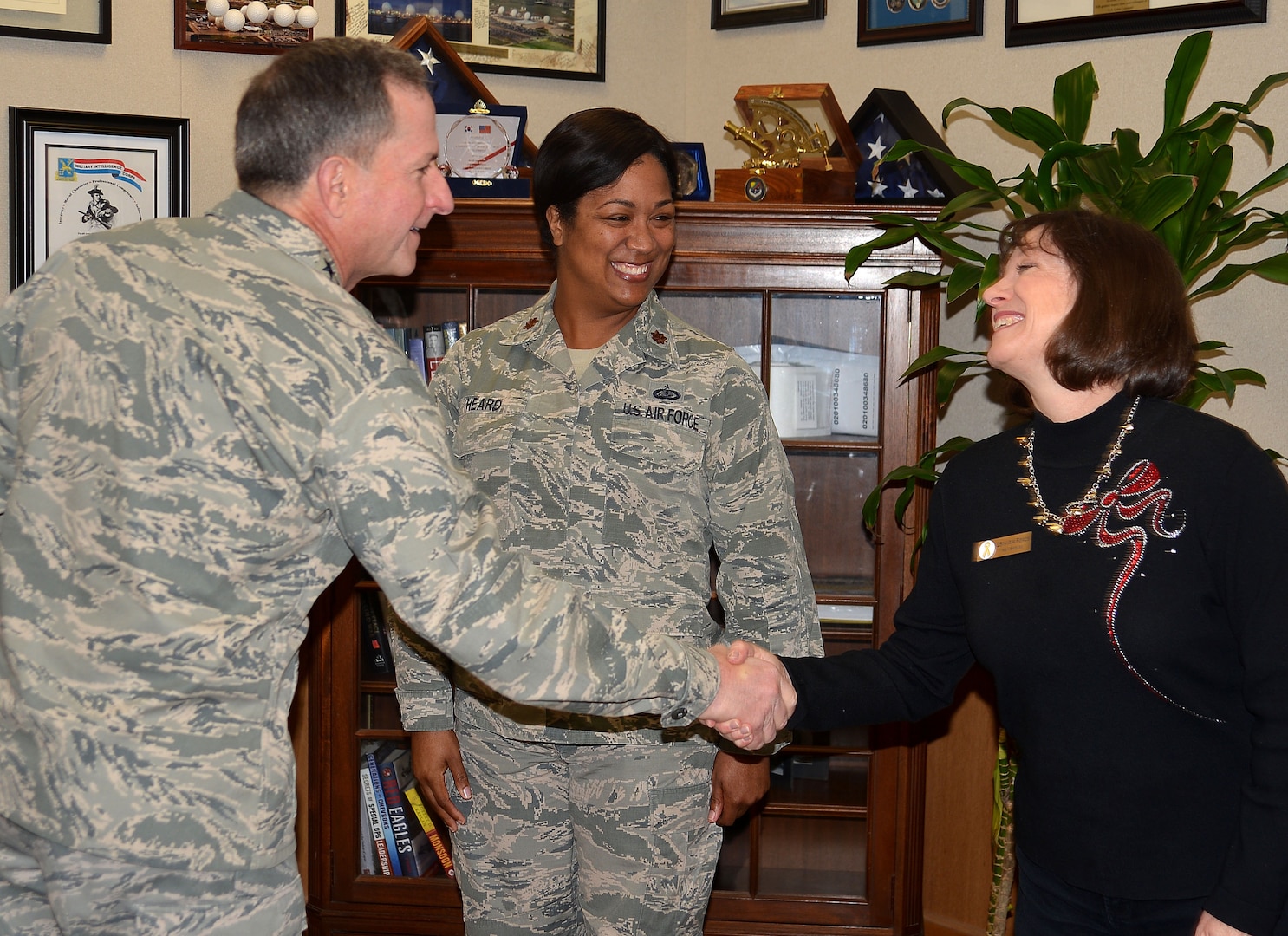 Air Force Chief of Staff Gen. David L. Goldfein presents his recognition coin to Maj. Octavia Heard, squadron section commander, and Carol Glover, spouse of 25th Air Force Command Chaplain (Col.) Bruce Glover and Key Spouse coordinator, during his visit to San Antonio, Texas, Dec. 19.