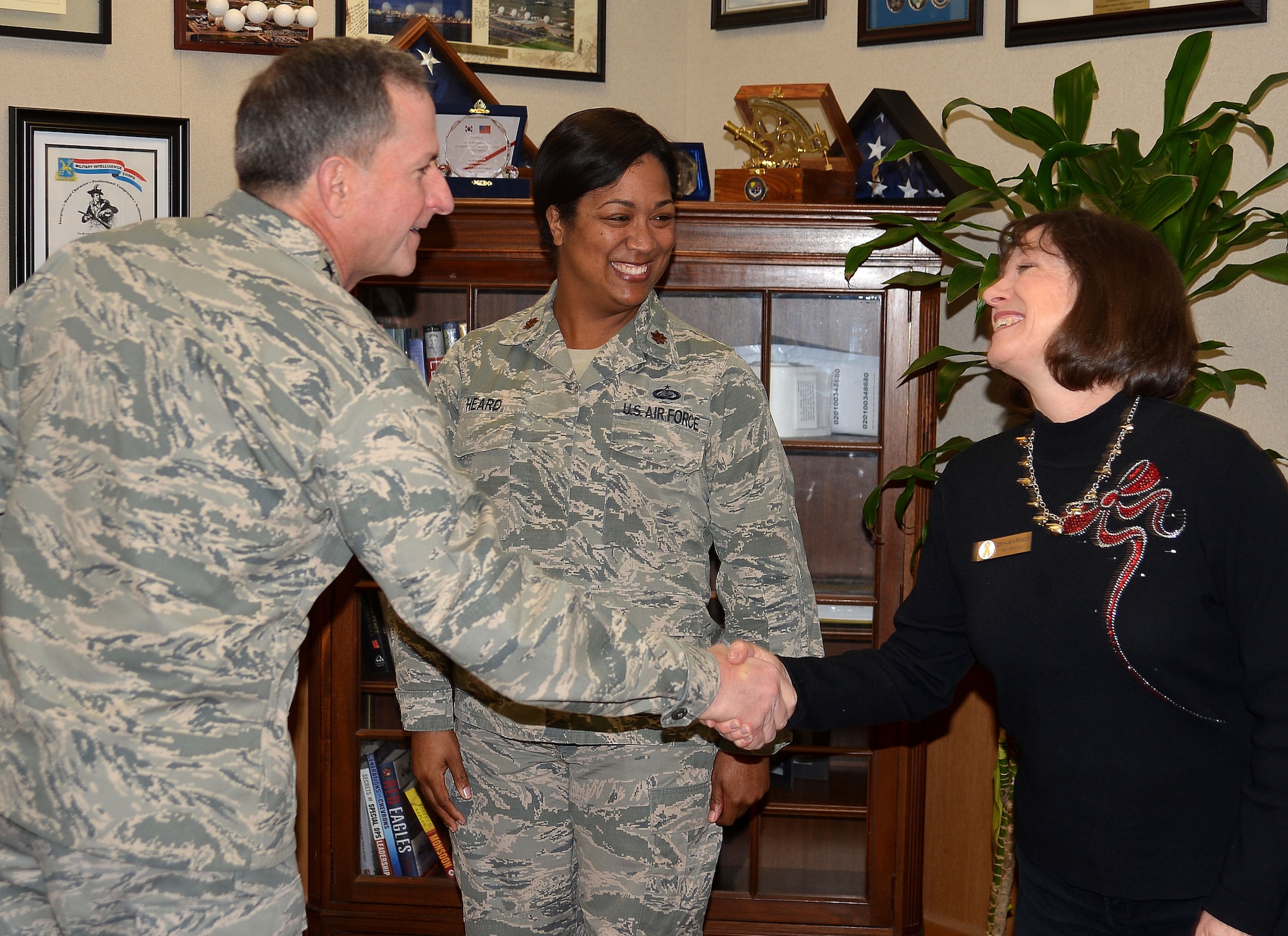 Air Force Chief of Staff Gen. David L. Goldfein presents his recognition coin to Maj. Octavia Heard, squadron section commander, and Carol Glover, spouse of 25th Air Force Command Chaplain (Col.) Bruce Glover and Key Spouse coordinator, during his visit to San Antonio, Texas, Dec. 19.