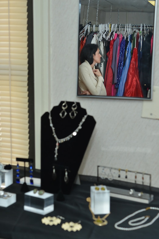 Yvonne Coombes, Operation Deploy Your Dress branch coordinator, looks at dresses hanging at the ODYD boutique at Joint Base Langley-Eustis, Va., Dec. 20, 2016. ODYD began in December 2015 and has given more than 2,000 dresses and accessories to military members and their families. (U.S. Air Force photo by Airman 1st Class Tristan Biese)