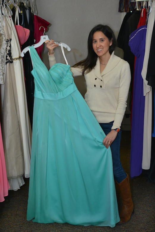 Yvonne Coombes, Operation Deploy Your Dress branch coordinator, displays a donated dress at Joint Base Langley-Eustis, Va., Dec. 20, 2016. Coombes, along with three other military spouses started ODYD to help military members and their spouses afford attending formal military events. (U.S. Air Force photo by Airman 1st Class Tristan Biese)
