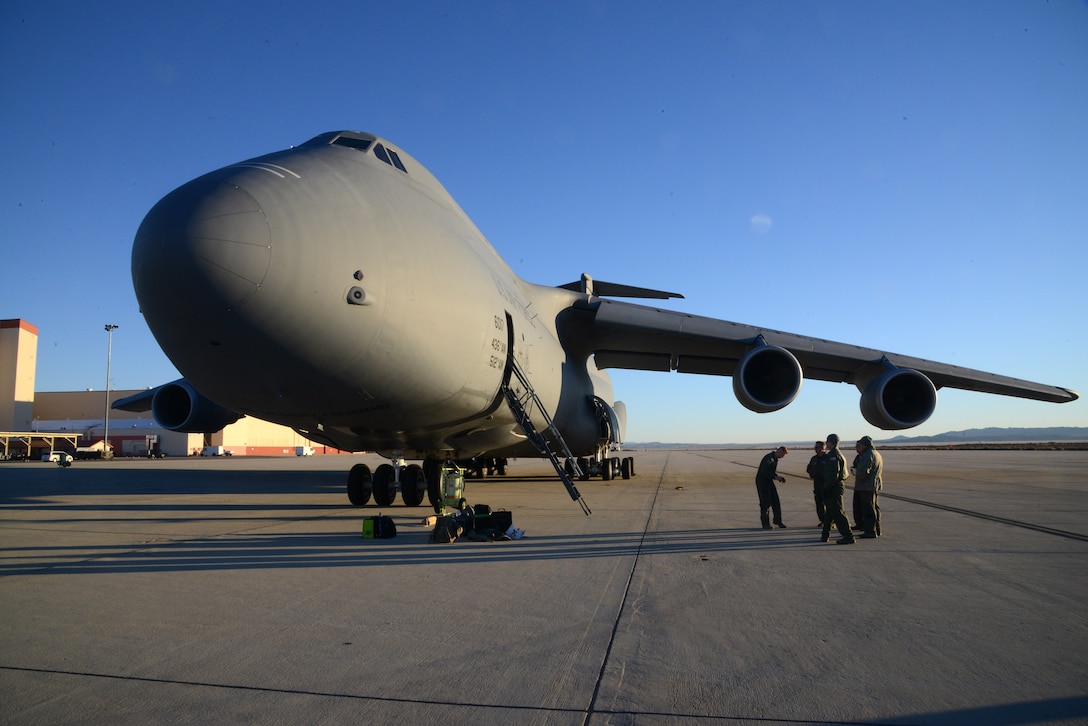 A C-5 Galaxy from Dover Air Force Base, Delaware, waits for a very special cargo on the flightline of Edwards Air Force Base, California, Dec. 19. The C-5 was loaded with the majority of a disassembled C-119B “Flying Boxcar” for transportation to the Air Mobility Command Museum at Dover AFB. This airplane, tail number 48-0352, was one of several that played a direct role in the Battle of Chosin Reservoir in the Korean War in 1950.  The aircraft will eventually be restored to its Korean War era configuration and displayed at the AMC Museum. (U.S. Air Force photo by Christopher Ball)