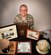 U.S. Air Force Capt. Norman Jones, 628th Air Base Wing chaplain, poses with memorabilia from his career Dec. 14, 2016, at Joint Base Charleston, South Carolina. Jones has given more than two decades of military service to his country while serving in the Navy, Army and then the Air Force.