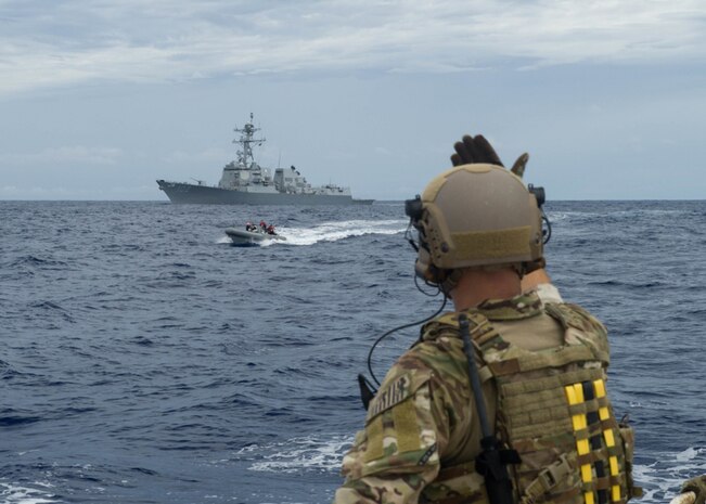 In this file photos, a U.S. Coast Guard Pacific Law Enforcement Detachment Team Boarding Officer signals a Rigid-Hull Inflatable Boat (RHIB) for pickup from Chinese fishing vessel during a Oceania Maritime Security Initiative (OMSI) mission with Arleigh Burke-class guided-missile destroyer USS Sampson (DDG 102). Sampson reports to U.S, Nov. 29, 2016. Third Fleet, headquartered in San Diego, while deployed to the Western Pacific as part of the U.S. Pacific Fleet-led initiative to extend the command and control functions of Third Fleet into the region.