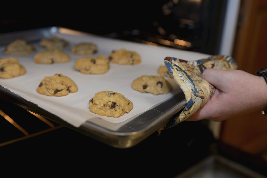 A batch of cookies for the Holiday Cookie Drive are finished baking at the Box Elder Event Center, S.D., Dec. 14, 2016. The cookie drive was established by the Enlisted Spouses' Club and the Officer and Civilian Spouses' Club to bring cheer to Airmen who don’t get to go home to see their families during the holiday season. (U.S. Air Force photo by Airman 1st Class Donald C. Knechtel)