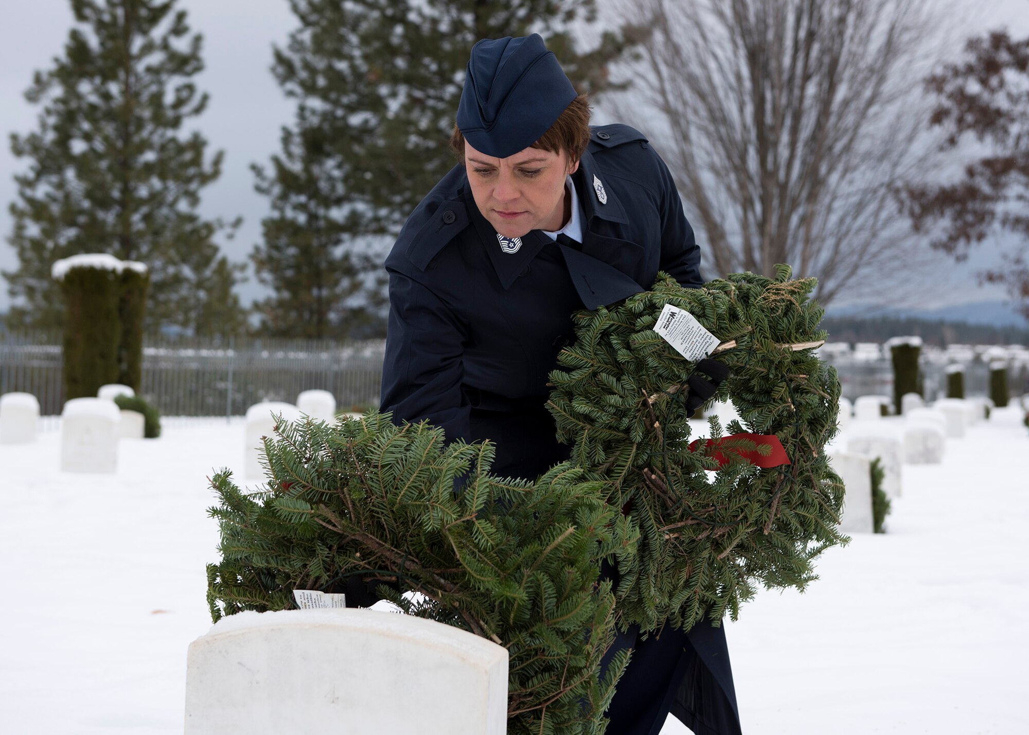 Chief Master Sgt. Shannon Rix, 92nd Air Refueling Wing command chief, places a wreath on a veteran's grave at the Fort George Wright Cemetery Dec. 19, 2016, near Spokane, Wash. Rix was part procession from Fairchild Air Force Base who honored deceased veterans during an official ceremony at the cemetery. (U.S. Air Force photo/Airman 1st Class Ryan Lackey)