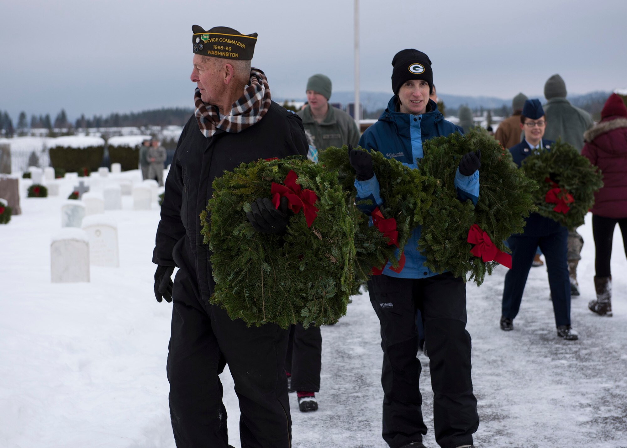 Ceremony attendees help distribute wreaths to the graves of service members buried at the Fort George Wright Cemetery Dec. 19, 2016, near Spokane, Wash. As part of the Wreaths Across America ceremony, attendees were encouraged to remember deceased veterans by reading the names on the headstones before laying a wreath on it. (U.S. Air Force photo/Airman 1st Class Ryan Lackey)