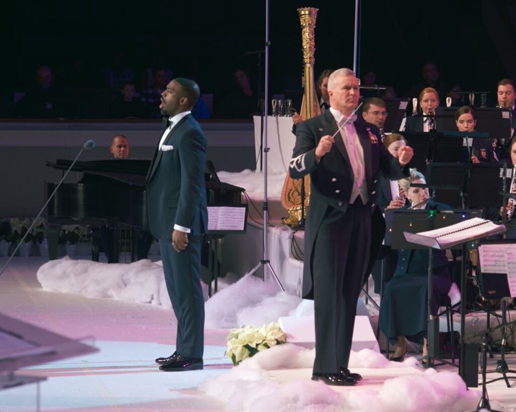 Colonel Larry Lang conducts the band as vocalist Soloman Howard performs for the 2016 Spirit of the Season concert. (US Air Force Photo by Chief Master Sgt Bob Kamholz/released)