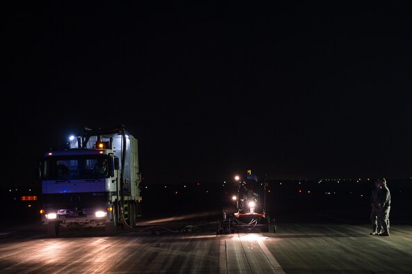 A maintenance crew removes excessive rubber buildup off of an active runway at an undisclosed in Southwest Asia, Dec. 15, 2016. Maintenance crews had roughly 5 minutes to evacuate the runways when aircraft were landing or departing. The strategic operation successfully enabled the 380th Air Expeditionary Wing to maintain its current level of support in Combined Joint Task Force-Operation Inherent Resolve. (U.S. Air Force photo/Senior Airman Tyler Woodward)