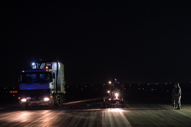 A maintenance crew removes excessive rubber buildup off of an active runway at an undisclosed in Southwest Asia, Dec. 15, 2016. Maintenance crews had roughly 5 minutes to evacuate the runways when aircraft were landing or departing. The strategic operation successfully enabled the 380th Air Expeditionary Wing to maintain its current level of support in Combined Joint Task Force-Operation Inherent Resolve. (U.S. Air Force photo/Senior Airman Tyler Woodward)