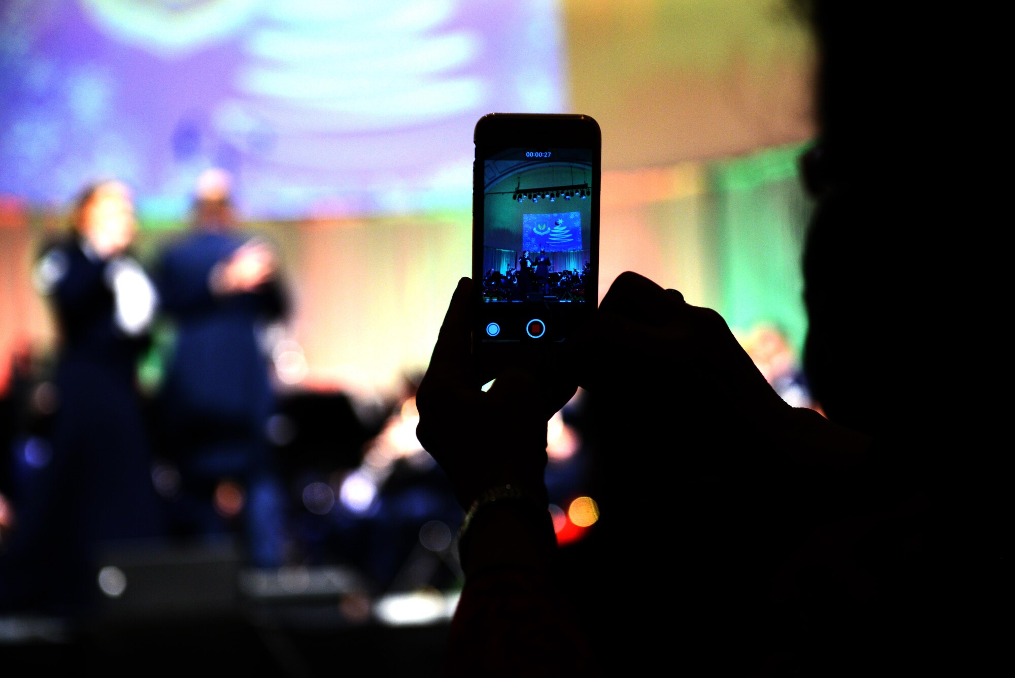 An audience member records a Christmas concert performed by the U.S. Air Forces Europe Band at Kaiserslautern, Germany. Dec. 16, 2016. Local nationals and U.S. military members attended the event, which aimed to bolster social and cultural ties between Americans and Germans. 