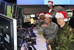 Eastern Air Defense Sector personnel conduct training in preparation for Santa tracking operations. Pictured from front to back, are: Sgt. Thomas Vance of the Royal Canadian Air Force, a member of EADS Canadian Detachment; and Master Sgt. Michelle Gagnon, Master Sgt. Lena Kryczkowski (standing) and Master Sgt. Shane Reid, all members of the New York Air National Guard's 224th Air Defense Squadron. NORAD begins tracking Santa on Christmas Eve.