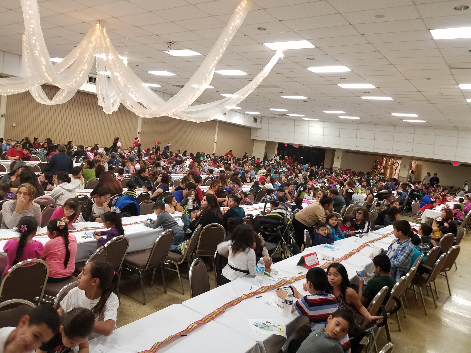 Nearly 1,000 children gathered at Niños Navideños, a charity, in the Civic Center in Del Rio, Texas, Dec. 17, 2016. Volunteers, many from Laughlin, presented 1,300 toys and 80 bicycles to children at the event.  The event began in 2004 and has grown every year. (U.S. Air Force photo/Joel Langton) (U.S. Air Force photo/Joel Langton)
