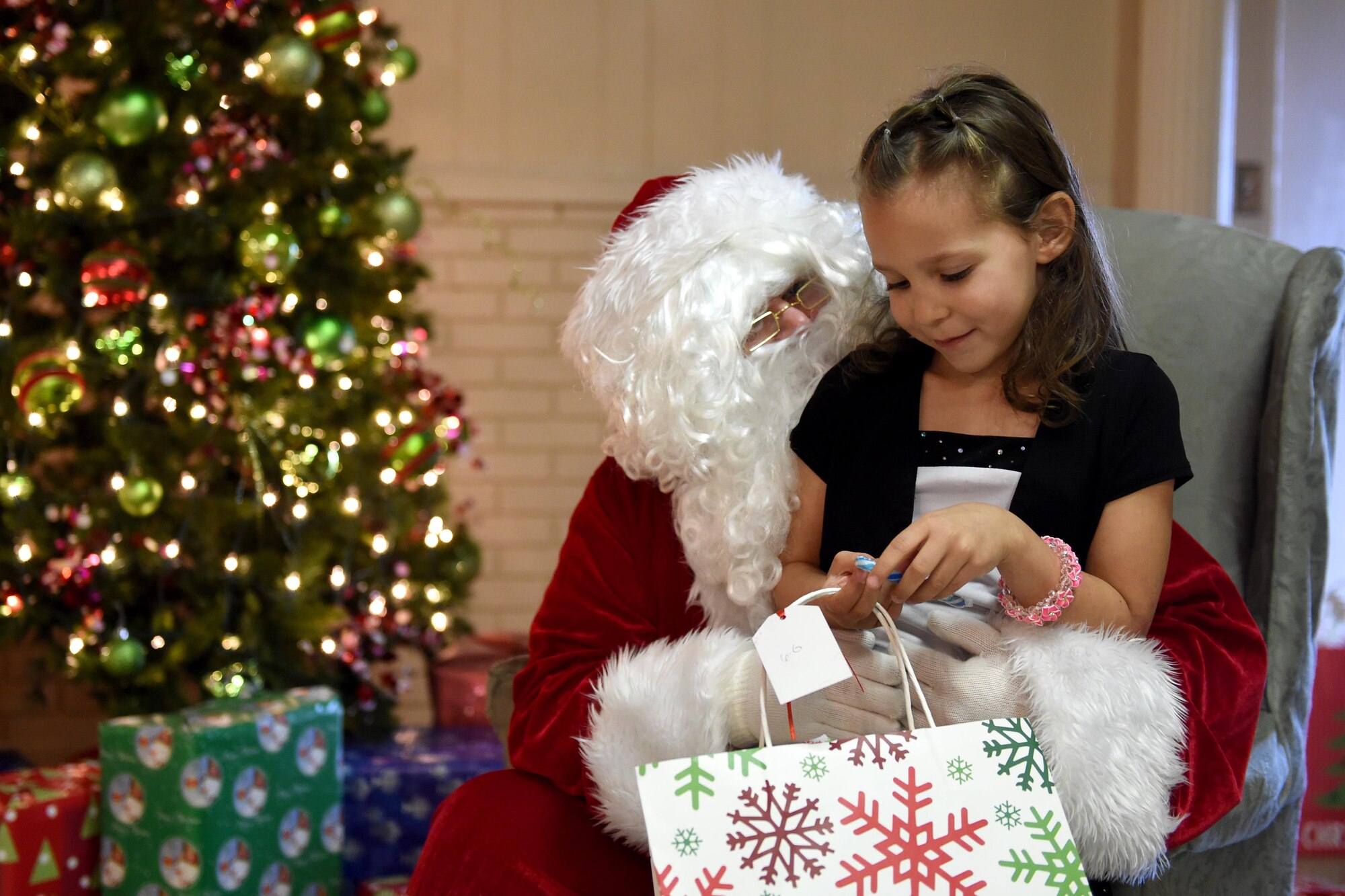 A child of a Soldier from the 316th Psychological Operations Company speaks to Santa during an annual family day in Kokomo, Ind., Dec. 10, 2016. The event included a special Welcome Home Warrior-Citizen ceremony for returning deployers and a promotion ceremony in addition to holiday festivities for Soldiers and their families. (U.S. Air Force photo/Tech. Sgt. Benjamin Mota)
