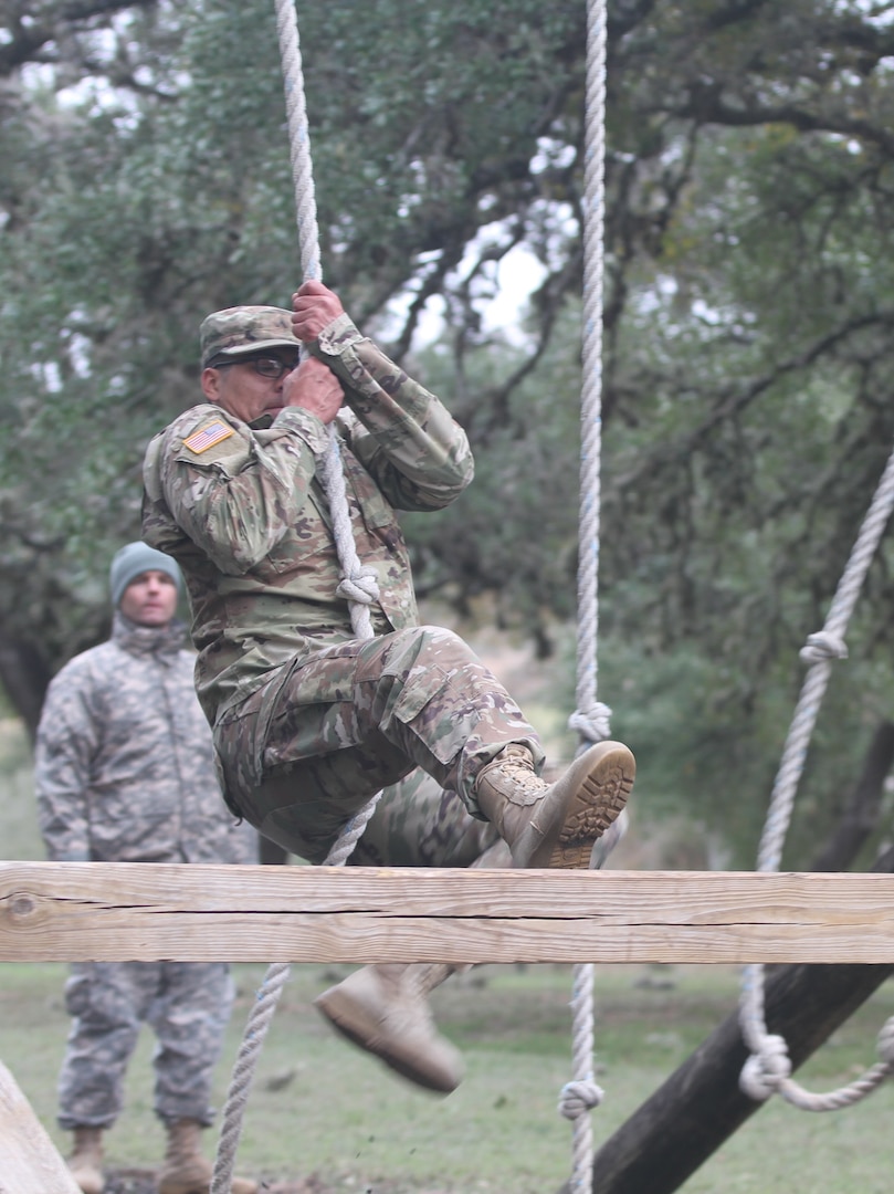 Pvt. Michael A. German, Military Funeral Honors Platoon, U.S. Army North (Fifth Army) at Joint Base San Antonio-Fort Sam Houston, swings over an obstacles on the confidence course during the annual Guardian Challenge at JBSA-Camp Bullis Dec. 9.