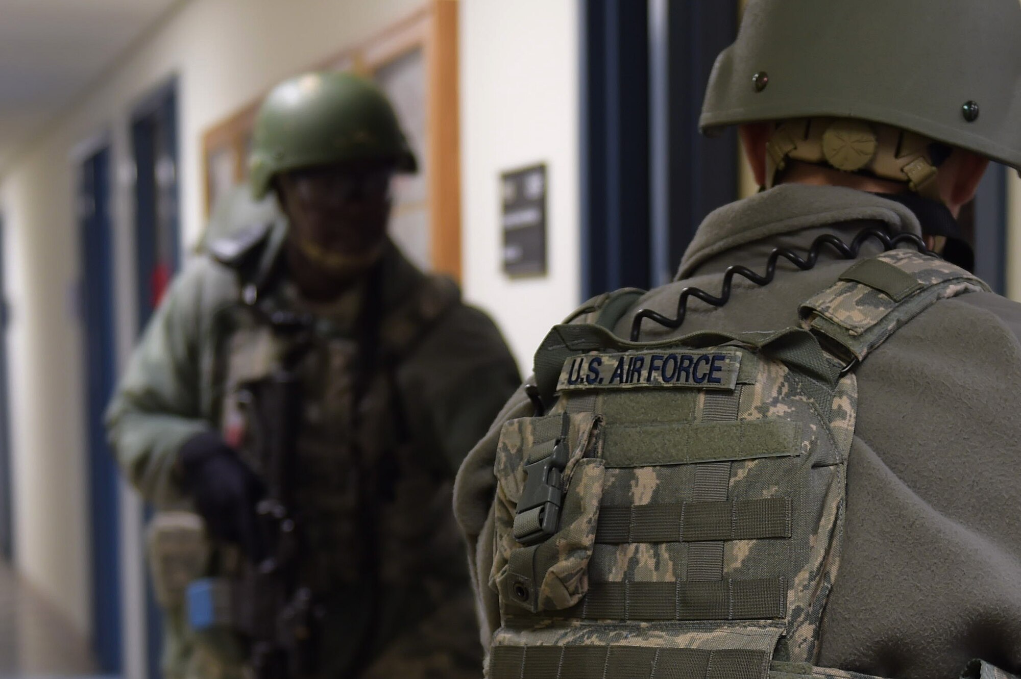 Members of the 633rd Security Forces Squadron clear rooms during an active shooter exercise at Joint Base Langley-Eustis, Va., Dec. 15, 2016. The 633rd SFS members checked each door and office to ensure there were no further threats. (U.S. Air Force photo by Senior Airman Kimberly Nagle)