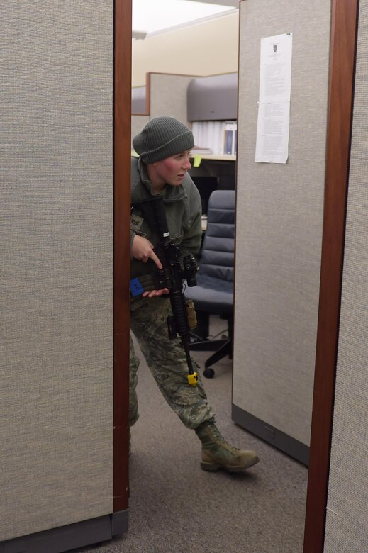 U.S. Air Force Staff Sgt. Nicole Johnston, 633rd Security Forces Squadron, NCO in charge of Police Services and Confinement, hides from incoming SFS members as the active shooter during an exercise at Joint Base Langley-Eustis, Va., Dec. 15, 2016. Shortly after Johnston fired shots, 633rd SFS first responders infiltrated the building eliminating her as an active shooter. (U.S. Air Force photo by Senior Airman Kimberly Nagle)