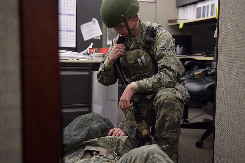 U.S. Air Force Airman 1st Class Brett Nott, 633rd Security Forces Squadron installation entry controller, calls the control desk to inform them he apprehended the active shooter during an exercise at Joint Base Langley-Eustis, Va., Dec. 15, 2016. Nott, eliminated the threat of the active shooter after a simulated shoot out. (U.S. Air Force photo by Senior Airman Kimberly Nagle)