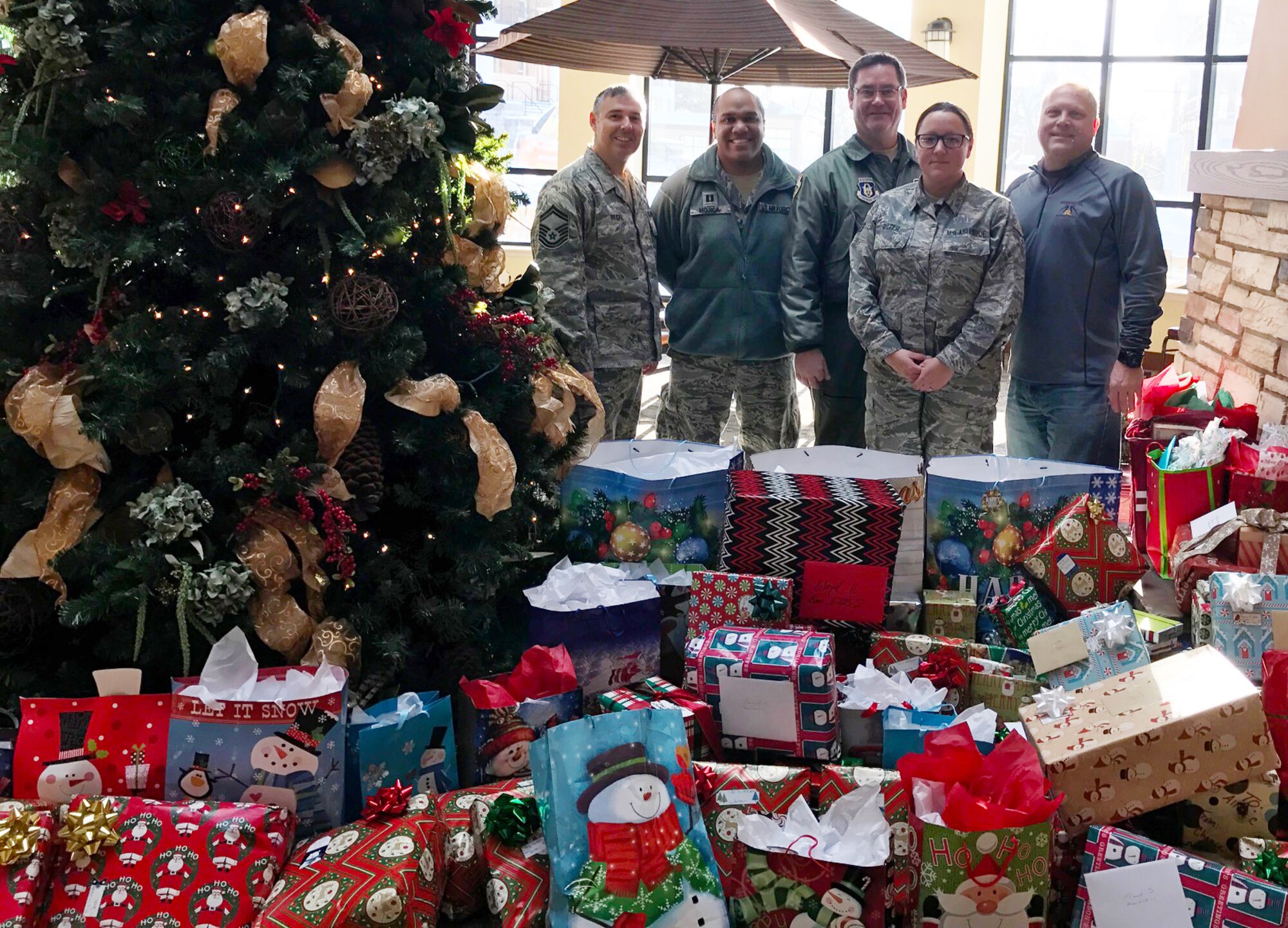 From left, Senior Master Sgt. Andy Regal, Capt. William-Joseph Mojica, Master Sgt. James Courneya, Senior Airman Jenny Delzer and rick Pelzl stand with the gifts delivered to the Minnesota Veteran's Home Dec. 1.
