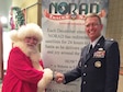 Lt. Col. Karl Fruendt shakes hands with Santa Claus at a NORAD Tracks Santa event. Lt. Col. Karl Fruendt is the voice behind the English-language videos on the NORAD Tracks Santa website and is also part of local holiday performances, narrating the history of the NORAD-run service. (Courtesy photo)