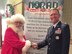 Lt. Col. Karl Fruendt shakes hands with Santa Claus at a NORAD Tracks Santa event. Lt. Col. Karl Fruendt is the voice behind the English-language videos on the NORAD Tracks Santa website and is also part of local holiday performances, narrating the history of the NORAD-run service. (Courtesy photo)