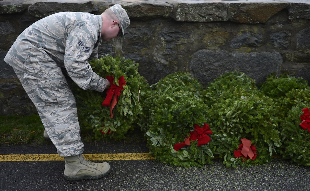 U.S. Air Force Senior Airman Derrick Stenstrom, 633rd Security Forces Squadron administration specialist, organizes wreaths for a National Wreaths Across America Remembrance ceremony at Hampton National Cemetery in Hampton, Va., Dec. 17, 2016. Volunteers from all military branches came together to honor the sacrifices of the veterans.(U.S. Air Force photo by Airman 1st Class Kaylee Dubois)