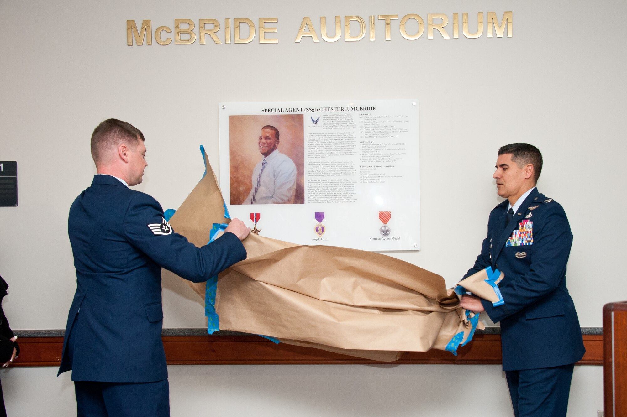 Maxwell AFB, Ala. - Colonel Eric Shafa, Commander, 42d Air Base Wing, and Staff Sergeant Joshua Williams, 42d Contracting Squadron, dedicate room NW201 in 42ABW headquarters building 804 as the McBride Auditorium, Dec. 21, 2016. Special Agent and Staff Sergeant Chester McBride was killed while protecting his interpreter from a suicide bomber near Bagram Air Base, Afghanistan on Dec. 21, 2015. McBride was assigned to the Air Force Office of Special Investigations, Detachment 405, Maxwell AFB.  (US Air Force photo by Melanie Rodgers Cox/Released)