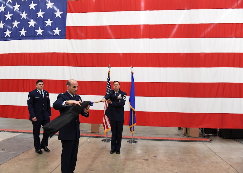 Col. Michael Manor, commander, 614th Air Operations Center and Joint Space Operations Center Director, uncases the 614th Combat Training Squadron guidon, during an activation ceremony Dec. 16, 2016 at Vandenberg Air Force Base, California.  As a new squadron under the 614th AOC, the 614th CTS will provide advanced training enabling the implementation and sustainment of Space Training Transformation and Space Mission Force initiatives and constructs across the unit. (U.S. Air Force photo by Capt. Nicholas Mercurio/Released)
