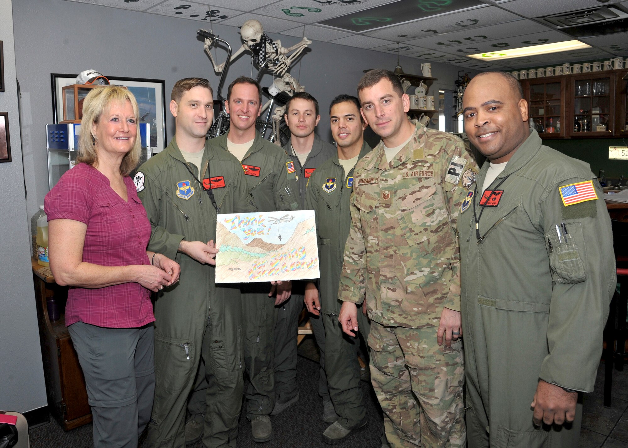 Ronda Ramsier poses with Airmen from the 58th Special Operations Wing and 512th Rescue Squadron with pictures created by neighborhood children thanking them for her rescue. Ramsier became stranded during an August hike near Durango, Colorado. More than 50 Airmen assisted in the 12 hour search-and-rescue mission. 
